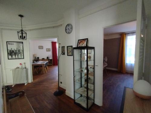 a living room with a glass cabinet in the middle at Toul superbe appartement plein centre in Toul