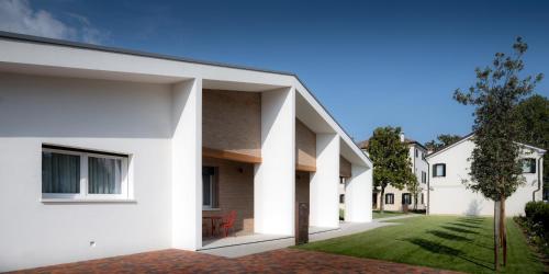 a house with white walls and a courtyard at The Foscarini in Mogliano Veneto