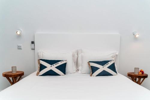 a bedroom with a white bed with blue and white pillows at Quinta do Charco in Ribeira Grande