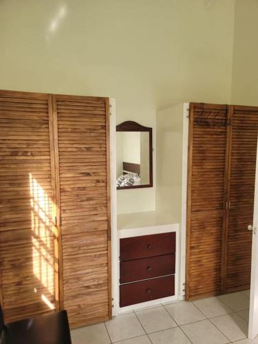 a room with two wooden doors and a dresser at Juju's Cottage with magnificent views in Laborie