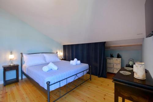 a bedroom with a bed with blue sheets and white pillows at History House in Corfu Town