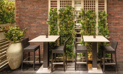 a patio with tables and chairs and plants at Dakota Glasgow in Glasgow