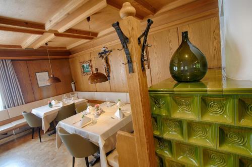 a restaurant with two tables and a vase on the wall at Hotel Lamm in Naturno