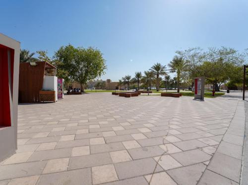 a large plaza with benches and trees in a park at Heritage Home Guest House in Dubai