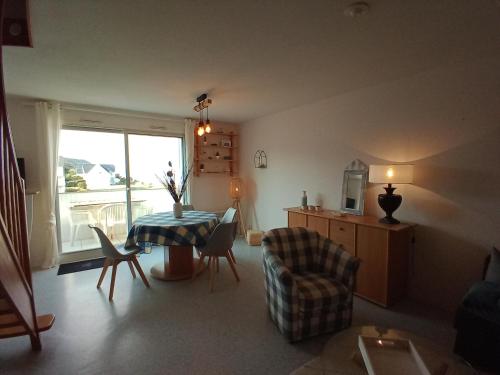 un salon avec une table et une chaise dans l'établissement DUPLEX les pieds dans l' eau, à Jullouville