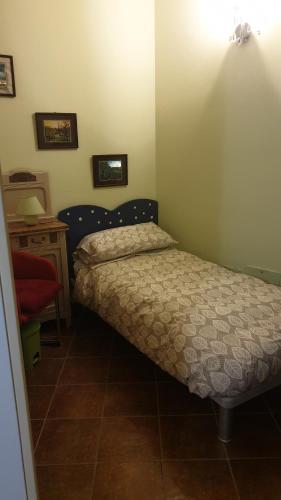 a small bedroom with a bed and a table at B&B Villa Giardini Susanna in Gattico