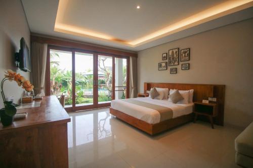 - une chambre avec un lit et une grande fenêtre dans l'établissement Queen at Gunung Sari, à Ubud