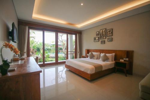 a bedroom with a bed and a large window at Queen at Gunung Sari in Ubud