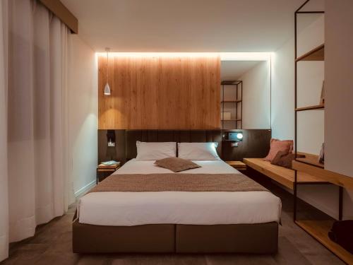 - une chambre avec un grand lit et une tête de lit en bois dans l'établissement Venice Green Residence, à Mestre