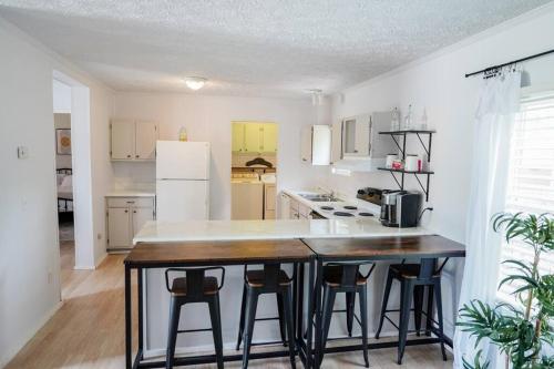 a kitchen with a table and some stools in it at Beautiful Stylish 3 bedroom home in Greenville in Greenville