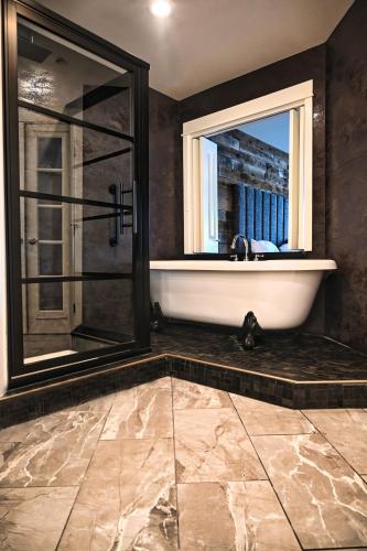 a bathroom with a bath tub and a window at Cannery Pier Hotel & Spa in Astoria, Oregon