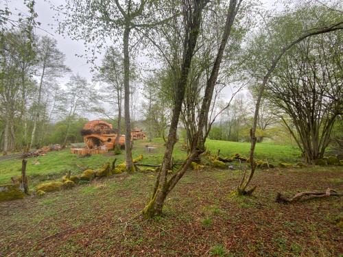 a house in the middle of a field with trees at Les Cabanes De Pyrene in Cazarilh
