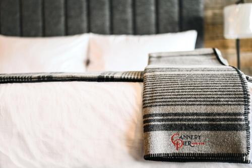 a close up of a bed with white sheets and pillows at Cannery Pier Hotel & Spa in Astoria, Oregon