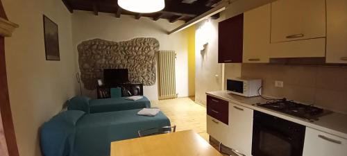 een woonkamer met een blauwe bank en een keuken bij Ai Gabbiani in Verona