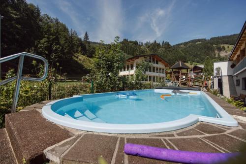 a large swimming pool in the middle of a yard at Hotel Salzburger Hof in Dienten am Hochkönig