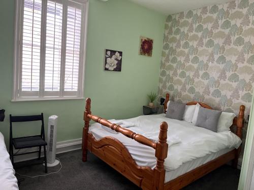 a bedroom with a wooden bed and a chair at The Crown Hotel in Southwell