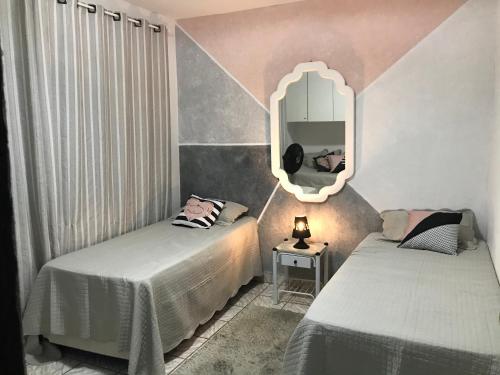 une chambre avec deux lits et un miroir dans l'établissement CHACARA THA&THI COND FECHADO WI FI SPA e PISC AQUECECIMENTO SOLAR, à Bom Jesus dos Perdões