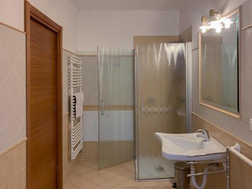 La salle de bains est pourvue d'une douche en verre et d'un lavabo. dans l'établissement Agritur al Vigneto, à Trente