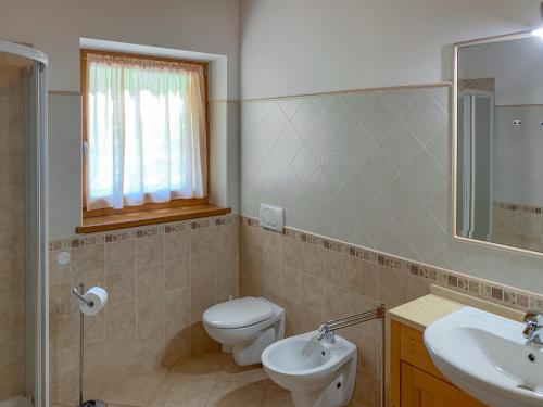 a bathroom with a toilet and a sink and a mirror at Agritur al Vigneto in Trento