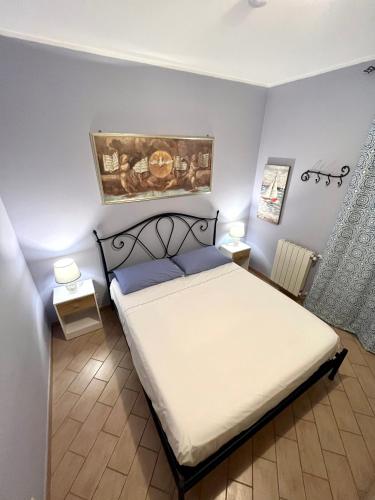 sypialnia z łóżkiem i obrazem na ścianie w obiekcie Sapore di sale, Capo D’Orlando w mieście Capo dʼOrlando