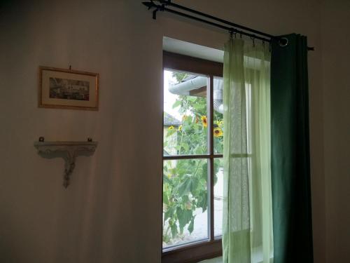 a window with a green curtain in a room at Kutny Residence -Chateau Schaal in Hegyhátsál