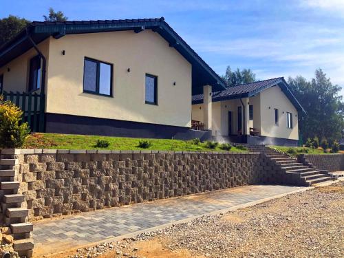 a house with a stone retaining wall in front of it at Zwillingshauser in Brebu Nou