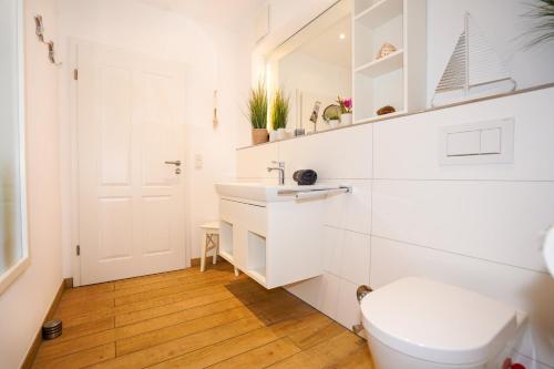 een witte badkamer met een toilet en een wastafel bij Ferienwohnung Daldrup 2 in Grömitz