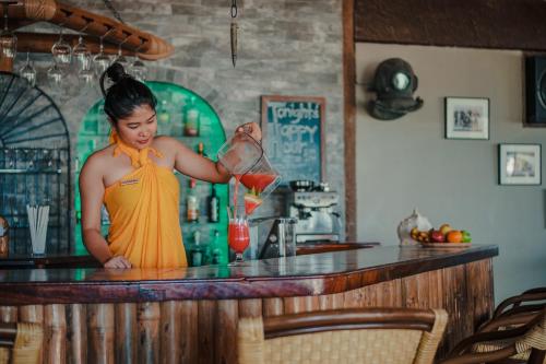 a woman standing at a bar making a drink at Sangat Island Dive Resort in Coron