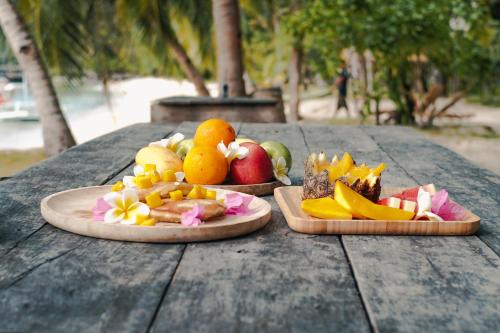 two plates of fruit on a wooden table at Sangat Island Dive Resort in Coron