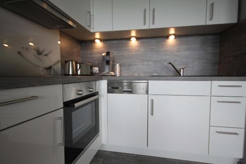 a kitchen with white cabinets and a black oven at Manhattan 516 mit Schwimmbad in Braunlage