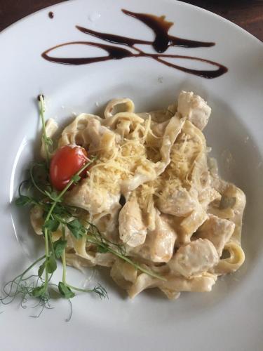 a plate of pasta with a tomato on top at Richky Hotel in Truskavets