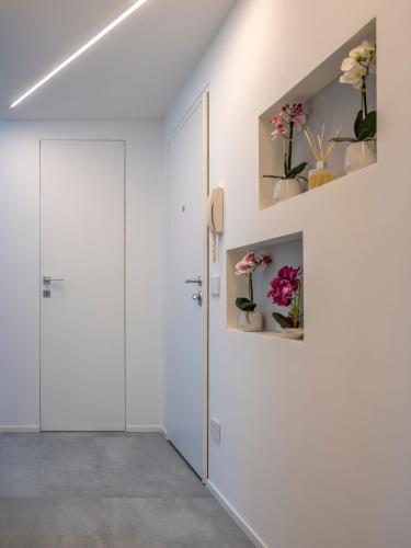 a hallway with white walls and a door with flowers on it at B&B Prestige in Corsico
