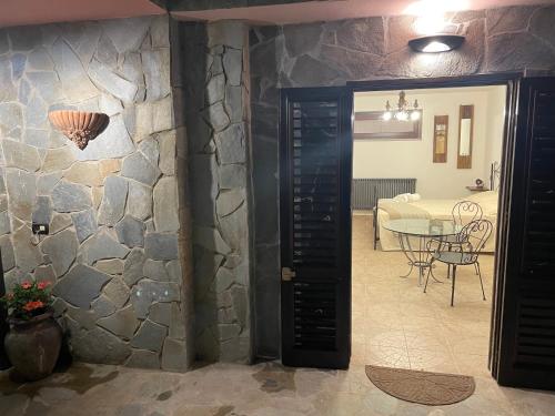 Habitación con pared de piedra, puerta y mesa. en ZuliHome, en Oliveri