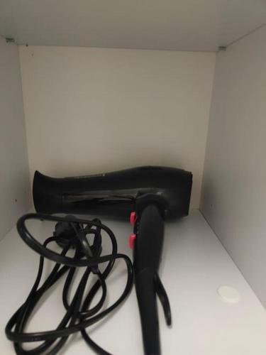 a black hair dryer sitting on top of a table at Apartament Japko in Gliwice