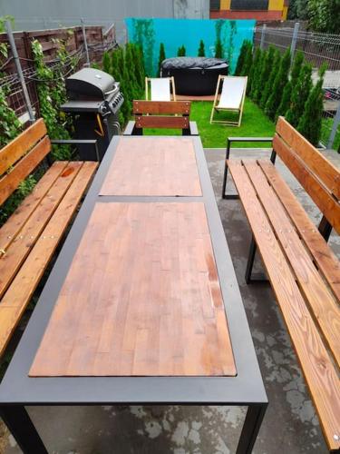 a picnic table with two benches and a grill at Apartament Japko in Gliwice