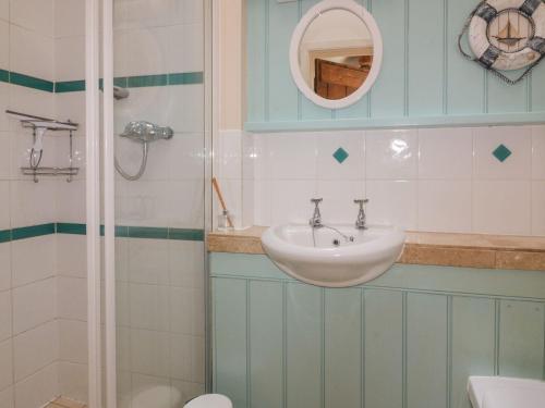 een badkamer met een wastafel en een douche bij Dovecote in Saint Goran