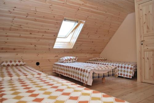 a attic room with two beds and a window at Ansumardi Farmstay in Kavandi