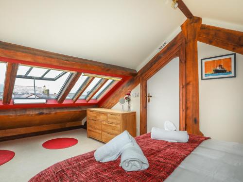 una camera da letto con un grande letto con una coperta rossa di Ty Biwmares a Beaumaris