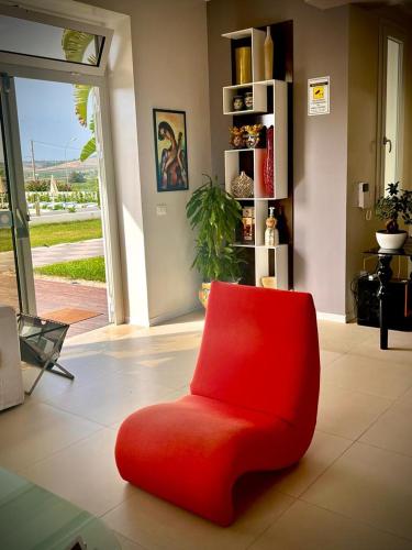 a red chair sitting in a living room at Villa Giadel in Menfi