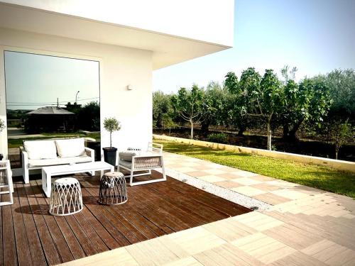 a patio with a table and chairs on a deck at Villa Giadel in Menfi