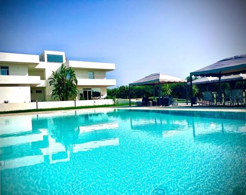 a large swimming pool in front of a building at Villa Giadel in Menfi