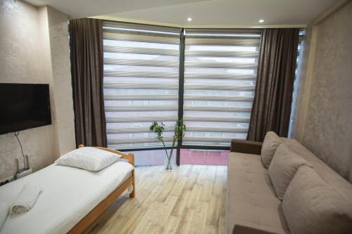 a bedroom with a bed and a large window at Apartmani Rekic-Dubai in Novi Pazar
