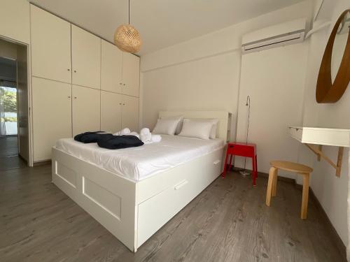 a bedroom with a white bed and a red chair at MV central in Rhodes Town