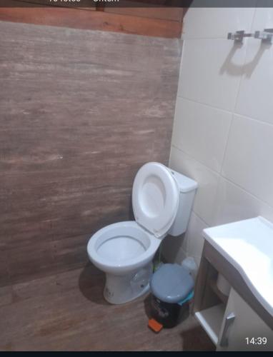 a bathroom with a white toilet and a sink at Chalé 3- Recanto Shambala in São Thomé das Letras