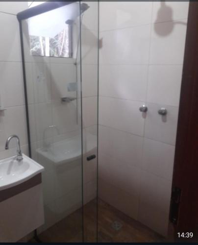 a bathroom with a glass shower and a sink at Chalé 3- Recanto Shambala in São Thomé das Letras