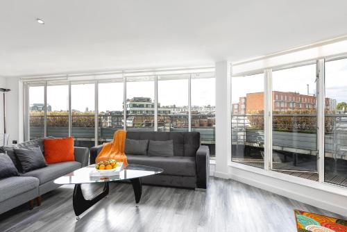 un soggiorno con divano e tavolo di *** Luxury DUPLEX Penthouse *** a Londra