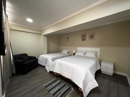 een hotelkamer met 2 bedden en een bank bij Departamentos Caraz in Caraz