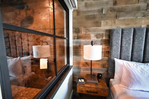 a bedroom with a wooden wall with a bed and a table at Cannery Pier Hotel & Spa in Astoria, Oregon