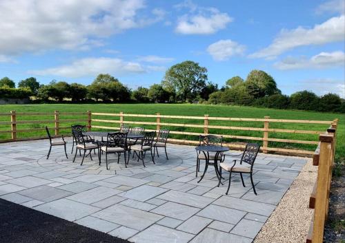 a patio with tables and chairs and a fence at Family Farmhouse in Claregalway