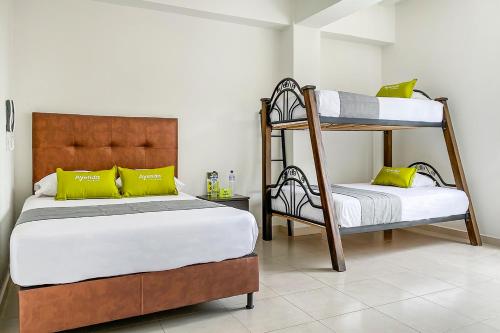Dosquebradas的住宿－Ayenda 1138 Apartahotel 109，一间卧室配有两张双层床和黄色枕头。
